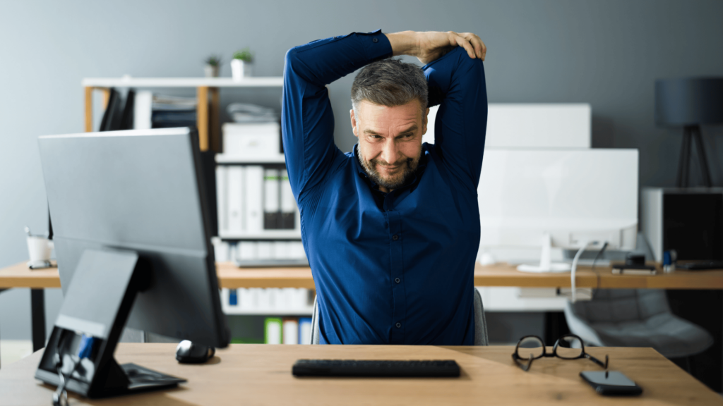 a man stretching at desk