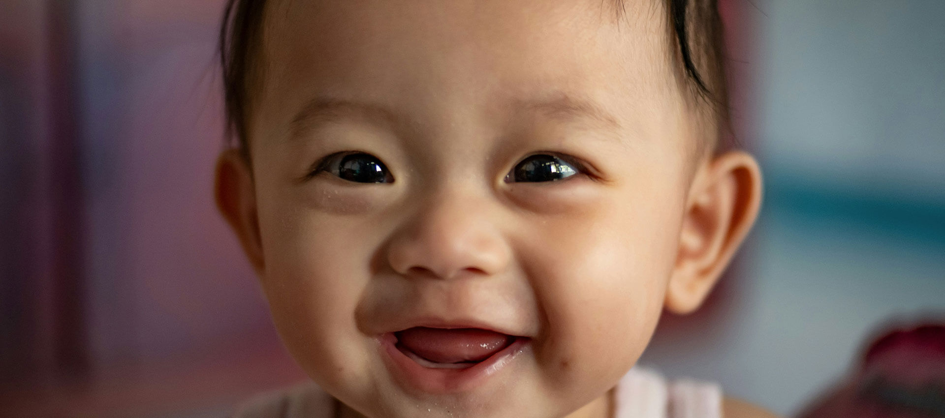 A close up image of a baby smiling.